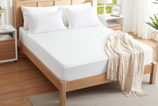 a bed with a mattress protector in a room