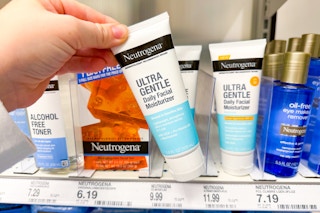 hand grabbing a bottle of neutrogena moisturizer
