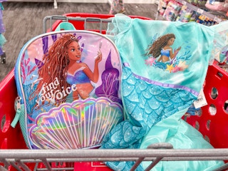 A Little Mermaid backpack and dress in a Target cart