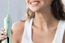 a woman using a green dental flosser