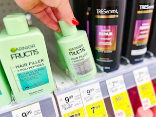 hand holding garnier hair filler bonding treatment in walgreens