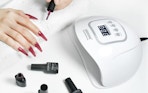 a person paint their nails next to a nail lamp