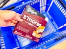 hand holding a box of breyers s-mores frozen sandwiches over walmart hand cart