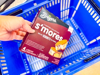 hand holding a box of breyers s-mores frozen sandwiches over walmart hand cart