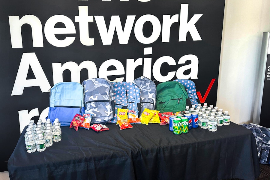verizon backpacks lined up on a table inside of a verizon store