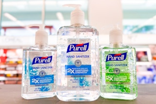 three bottles of purell hand sanitizer on store counter