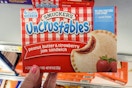 hand holding a box of smuckers uncrustables at kroger