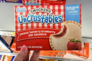 hand holding a box of smuckers uncrustables at kroger