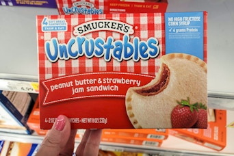 hand holding a box of smuckers uncrustables at kroger