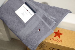 grey tommy hilfiger bath towel on a bath tub