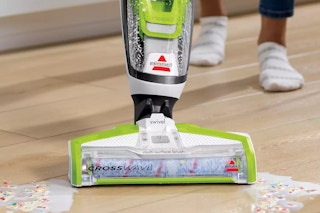 someone using the Bissell CrossWave to pick up some spilled cereal on the floor