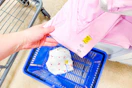 hand grabbing a pink shirt off a shelf with a yellow clearance tag