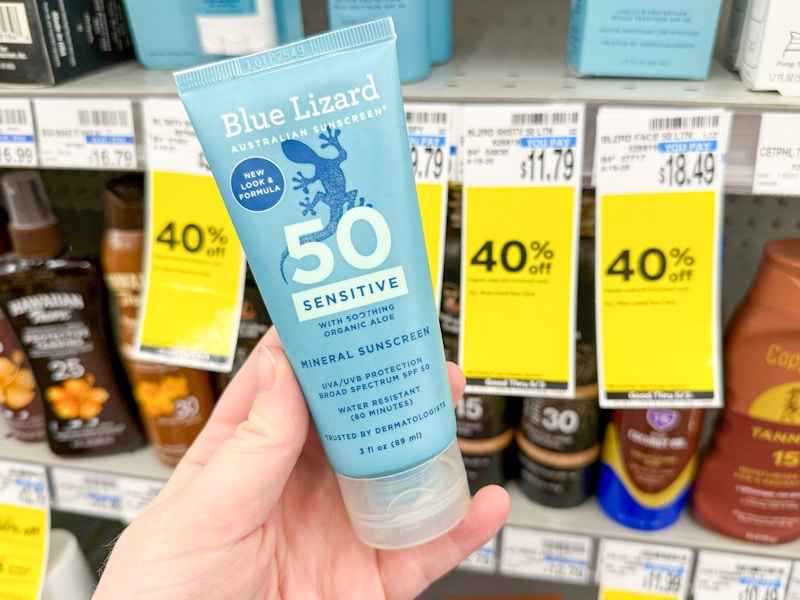 person holding blue lizard sunscreen by a 40% off sale tag