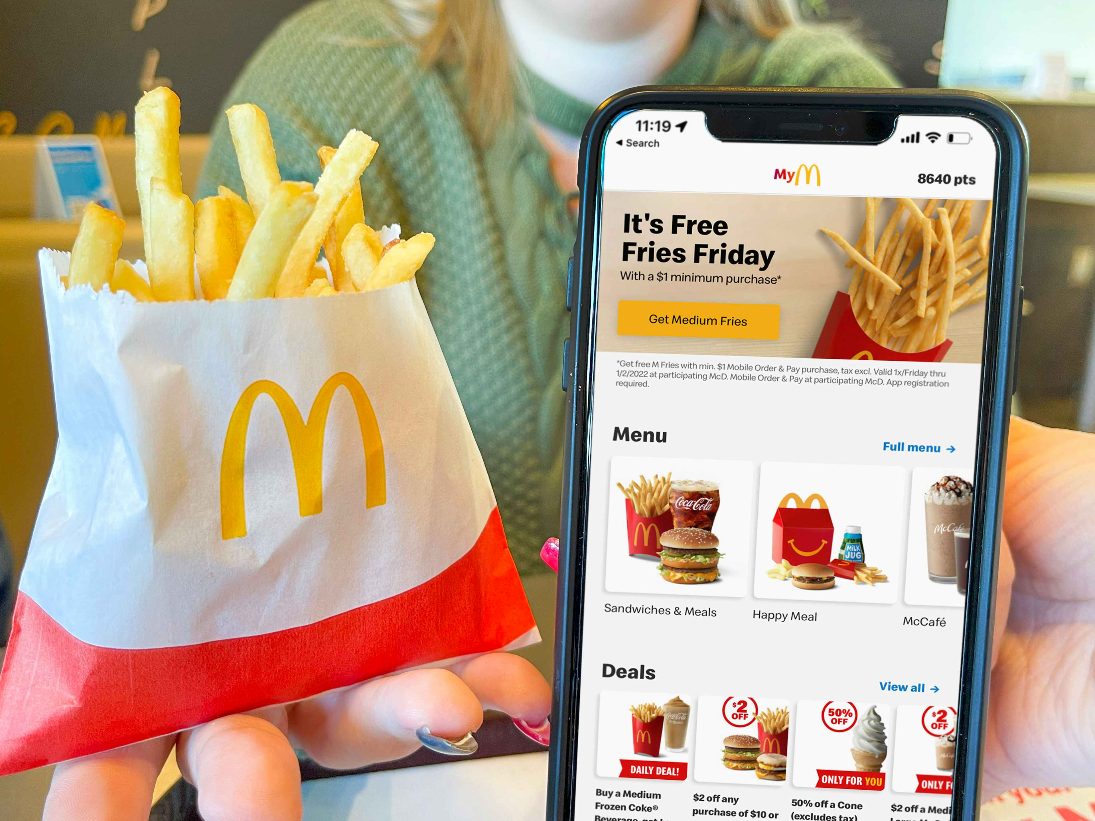 women holding cellphone with mcdonalds app and french fries