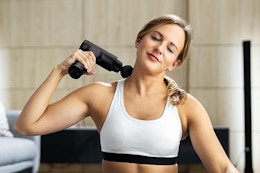 a woman using a massage gun
