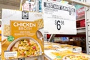 members mark chicken broth on store shelf with signage