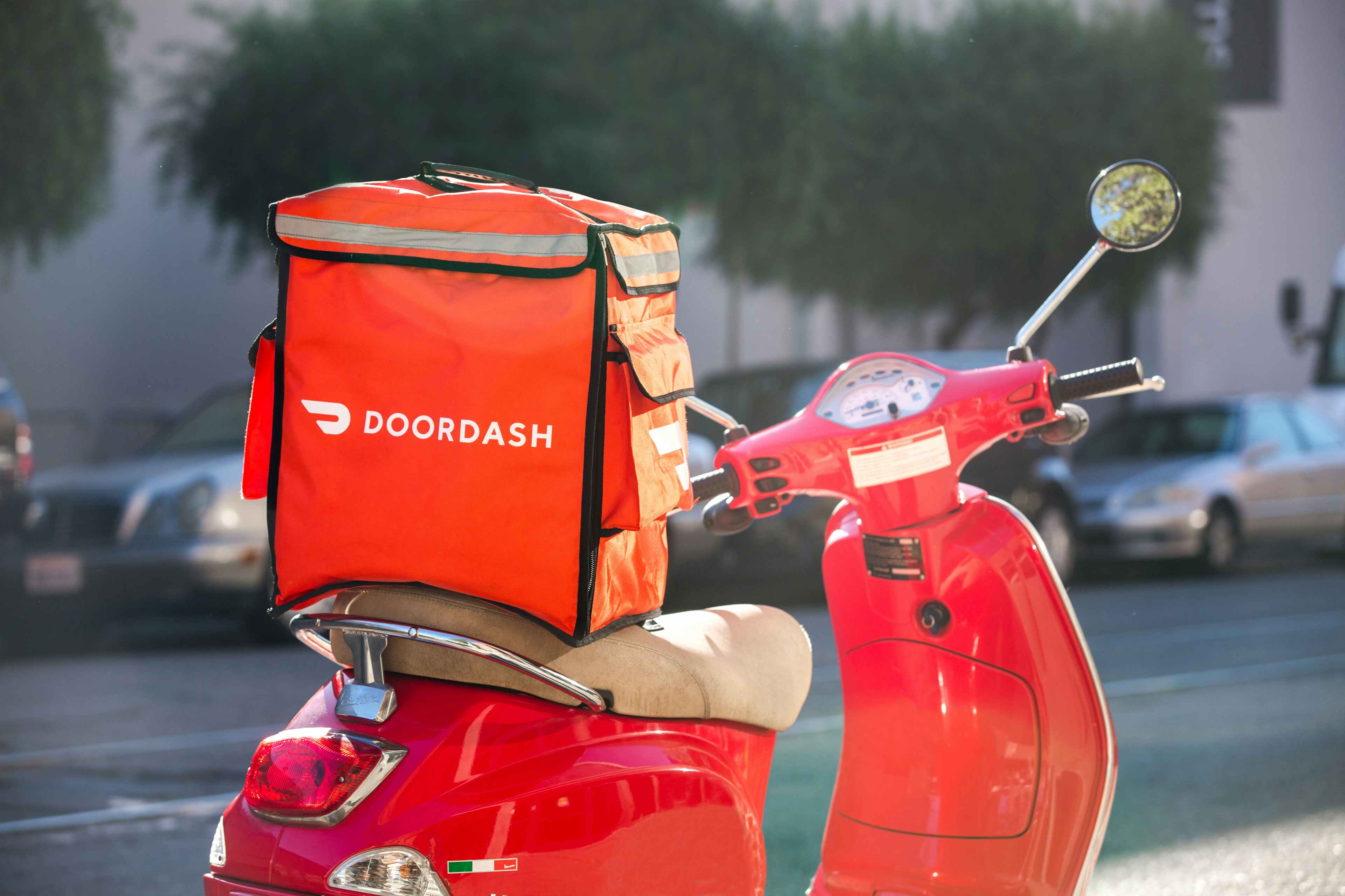 A doordash food bag on a red scooter