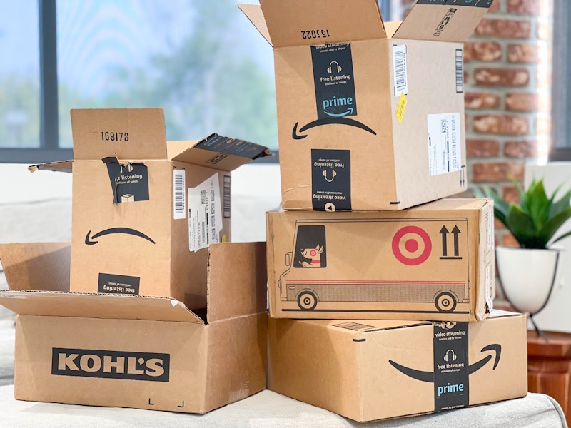 a pile of store online shopping boxes stacked up in living room