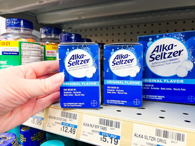 person grabbing alka-seltzer tablets off a shelf