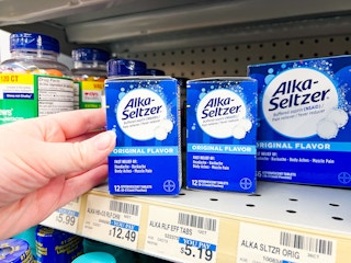 person grabbing alka-seltzer tablets off a shelf