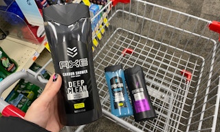 hand holding bottle of Axe body wash in front of shopping cart