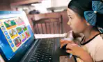 A child and parent looking at ABCmouse on a computer.