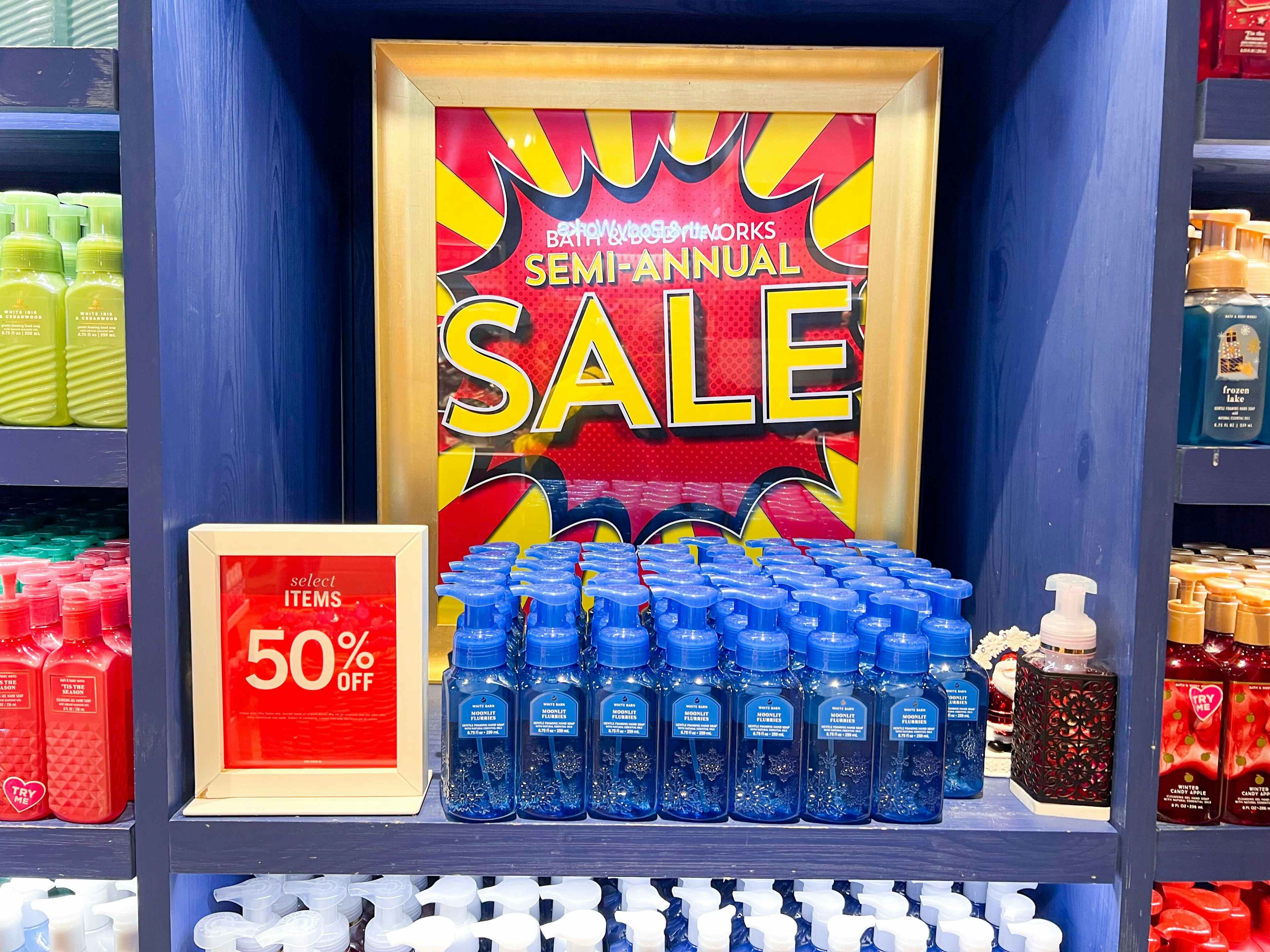 hand soaps on shelf in front of bath and body works semi annual sale sign