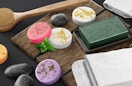 colorful shower steamers on a table with soap and a shower brush