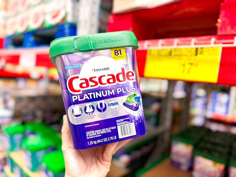 person holding a tub of cascade dishwasher pods