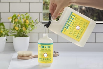 someone filling up a container with the Mrs. Meyer's Clean Day Liquid Hand Soap Refill
