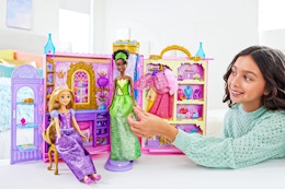 Lifestyle image of girl playing with the Disney Princess Ready for the Ball Closet Playset
