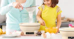 a mom and daughter masking sourdough bread on a kitchen counter