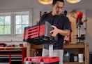 man carrying the red and black Craftsman Versastack tool chest