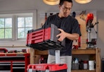 man carrying the red and black Craftsman Versastack tool chest