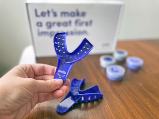 a hand holding a dental impression tray