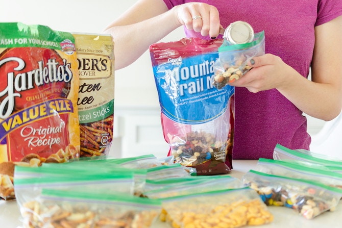 Woman putting snacks into individual bags.