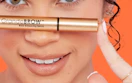 a person holding a tube of brow serum