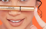a person holding a tube of brow serum