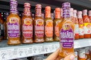 hand holding a bottle of tabanero hot sauce in walmart aisle