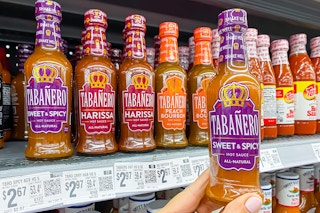 hand holding a bottle of tabanero hot sauce in walmart aisle