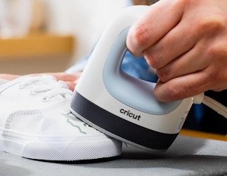 a person using a Cricut EasyPress mini on a sneaker