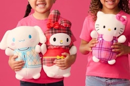 girls holding squishmallows plushes