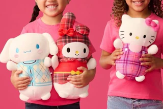 girls holding squishmallows plushes