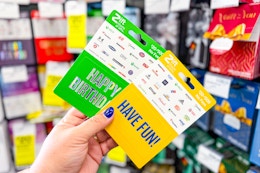 person holding 2 gift cards by the display