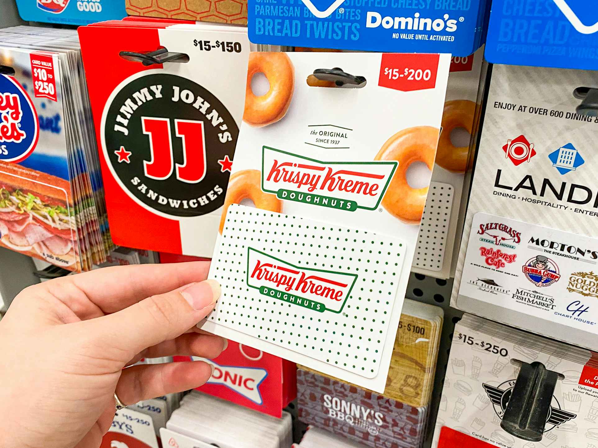 someone holding a Krispy Kreme gift card by amazon packaging