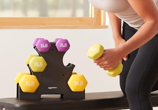 a dumbbell rack with weights on a table next to a person