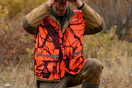 man wearing hunting vest in a field
