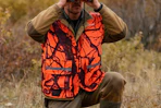 man wearing hunting vest in a field
