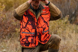 man wearing hunting vest in a field
