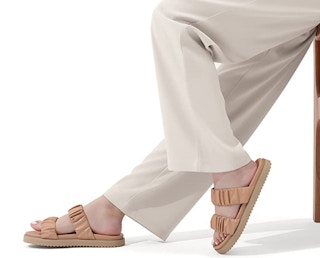 A person wearing ruched slide sandals.